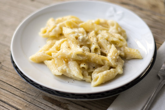 Cremige Pasta mit Blumenkohl und Gorgonzola, garniert mit IU Za’atar, serviert in weißer Schale auf dunklem Untergrund, Herbstgericht.