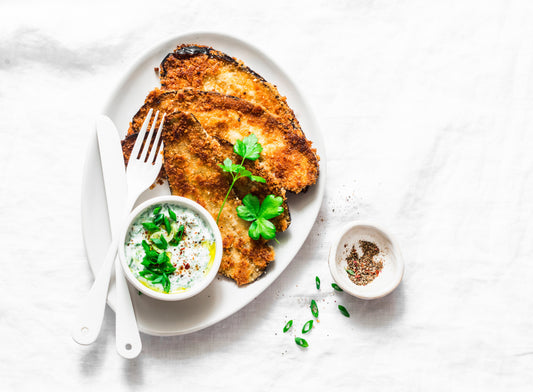Knusprige Auberginen-Schnitzel mit Panko-Panade auf hellem Hintergrund – vegetarisches Rezept mit Dip aus Mayo oder Bananenketchup und Crispy Chili Öl