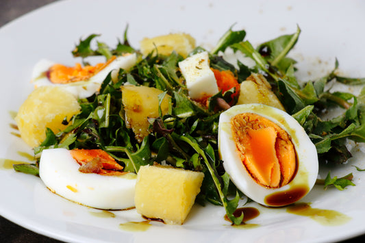 Feldsalat mit Austrian Chili Crisp, gekochten Eiern und Kartoffeln auf Keramik Teller angerichtet