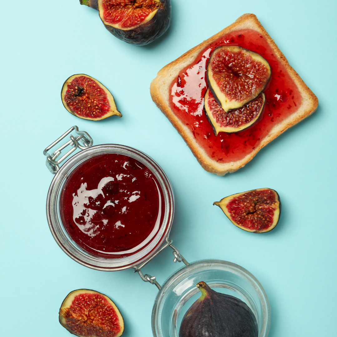 Offenes Marmeladen glas neben bestrichenem Toast und frischen Feigen